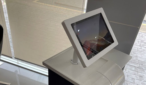 White digital touchscreen kiosk on a modern white countertop